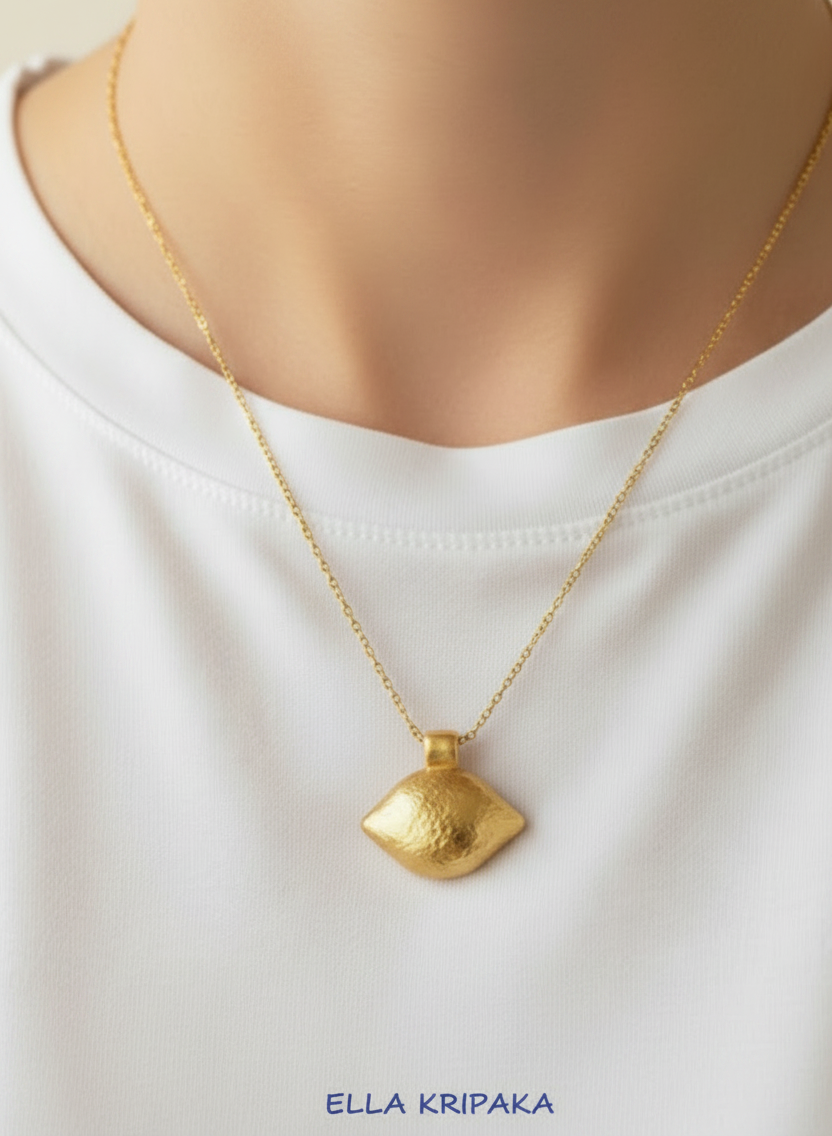24k gold hammered oval dome textured pendant shiny is on chain wearing on person in a white t-shirt, artist's name 'Ella Kripaka'
