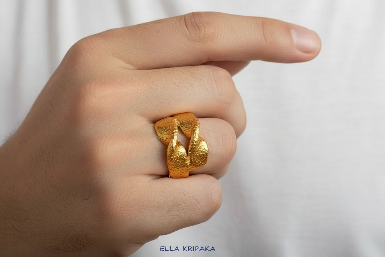 Twisted hammered 24k 9999 Gold ring signet with textured gold worn on person's finger and on a white surface, artist-jeweler's name 'Ella Kripaka' is written on picture
