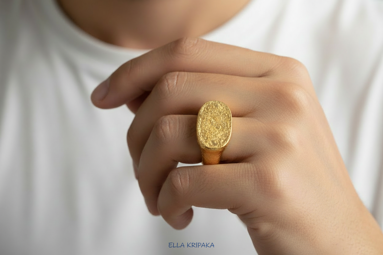 Hammered 24k 9999 Gold ring thick signet Ancient Egypt style and Ancient Rome style and with forged textured gold worn on model's finger and on a white plain background, artist-jeweler's name 'Ella Kripaka' branding