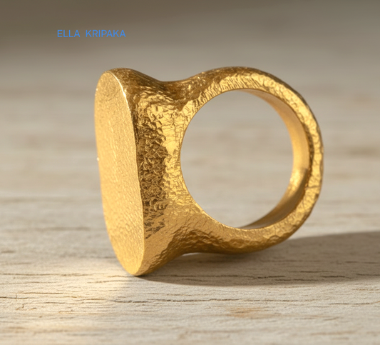 Hammered 24k 9999 Gold ring thick signet Ancient Egypt style and Ancient Rome style and with forged textured gold on a light old wooden surface, artist-jeweler's name 'Ella Kripaka' branding