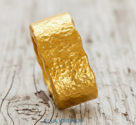 Organic hammered 24k 9999 Gold wavy ring band with thick wavy edges and with forged gold textures on white old wooden surface, artist-jeweler's name 'Ella Kripaka' branding