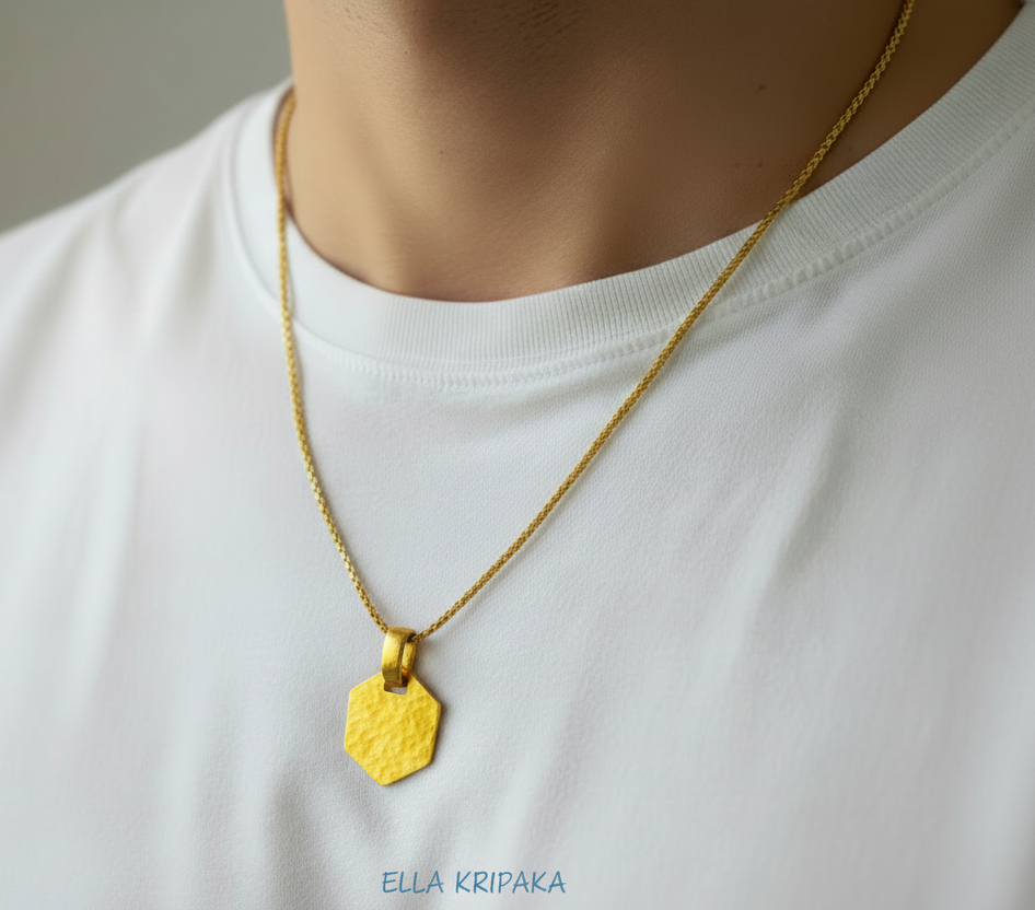 Hammered 24k gold, pure 9999 gold hexagon pendant on chain worn by a man and with white t-shirt and on grey background, artist-jeweler 'Ella Kripaka' branding