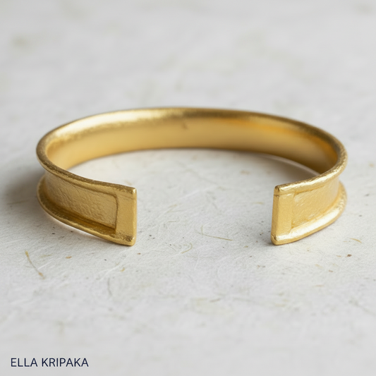 Hammered 24k gold bracelet textured cuff Ancient Rome style with durable folded edges on white rise paper surface, branding artist-jeweler 'Ella Kripaka'
