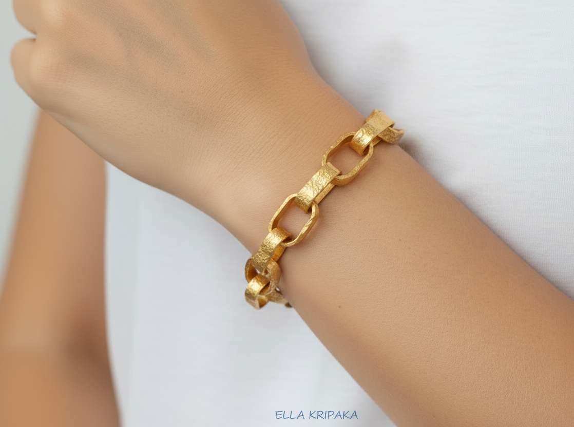 Hammered 24k 9999 gold chain thick bracelet Ancient Rome style worn by a woman on wrist and on a neutral background, artist-jeweler name 'Ella Kripaka' branding