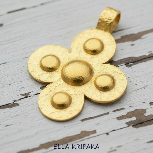 24k gold hammered Byzantine cross pendant with five convex rounds is on a old white wooden surface, and artist's name 'Ella Kripaka' branding