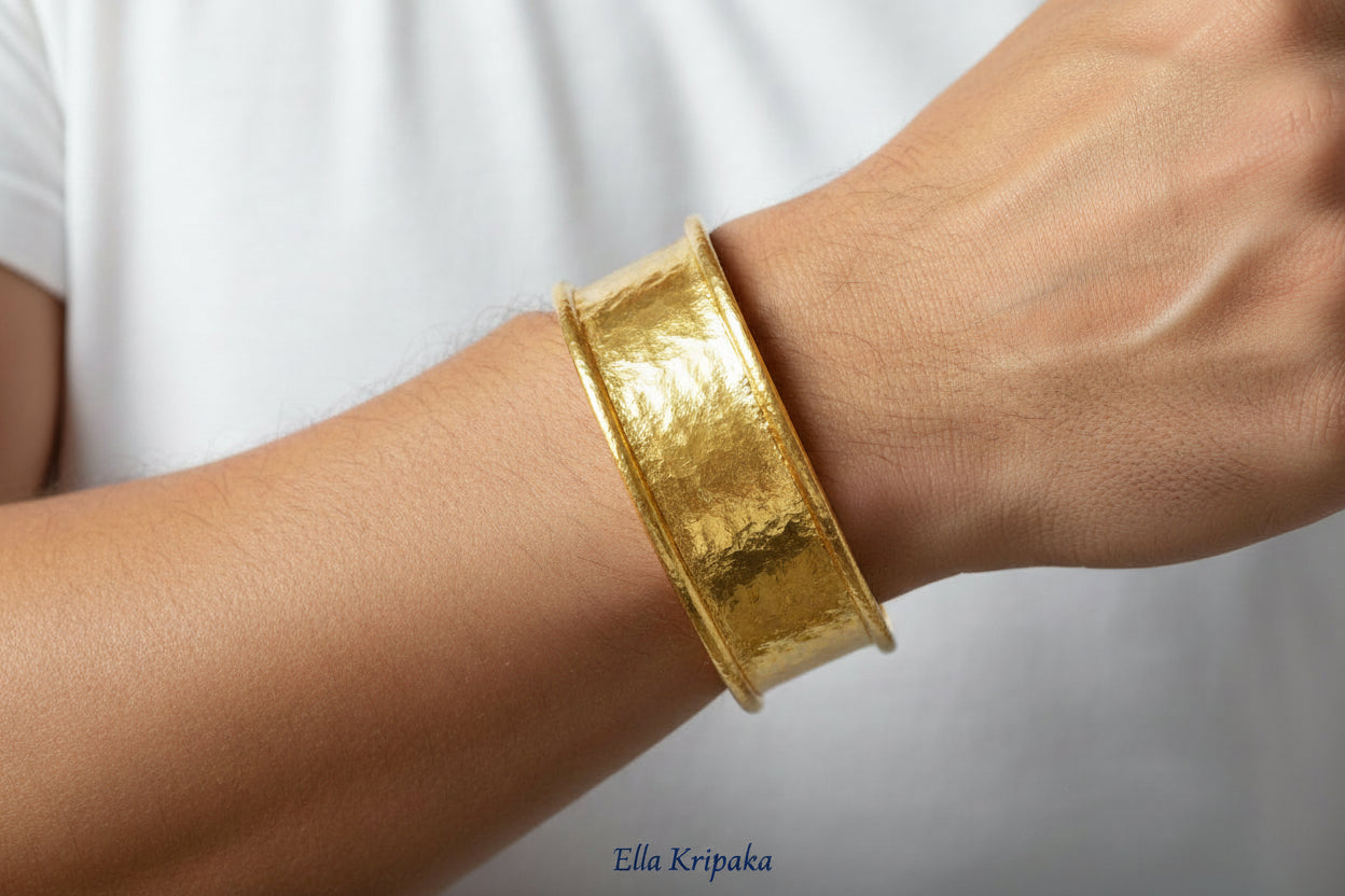 Hammered 24k 9999 gold bracelet cuff Ancient Rome style worn by a person and with a plain background, branding artist-jeweler name 'Ella Kripaka'