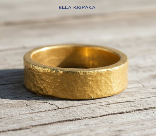 Hammered 24k 9999 Gold thick ring Ancient Rome style with a textured gold on old wooden surface, branded 'Ella Kripaka' artist-jeweler