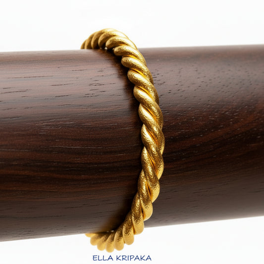 Twisted Viking Hammered 24k 9999 gold bracelet thick cuff on a dark wooden stand and on a white background, branding artist-jeweler name 'Ella Kripaka'