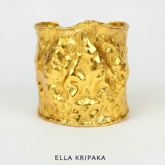 Hammered 24k gold large cuff bracelet, heavy 160g, with convex uneven textures and with 65 mm of width on a white background, with 'Ella Kripaka' branding
