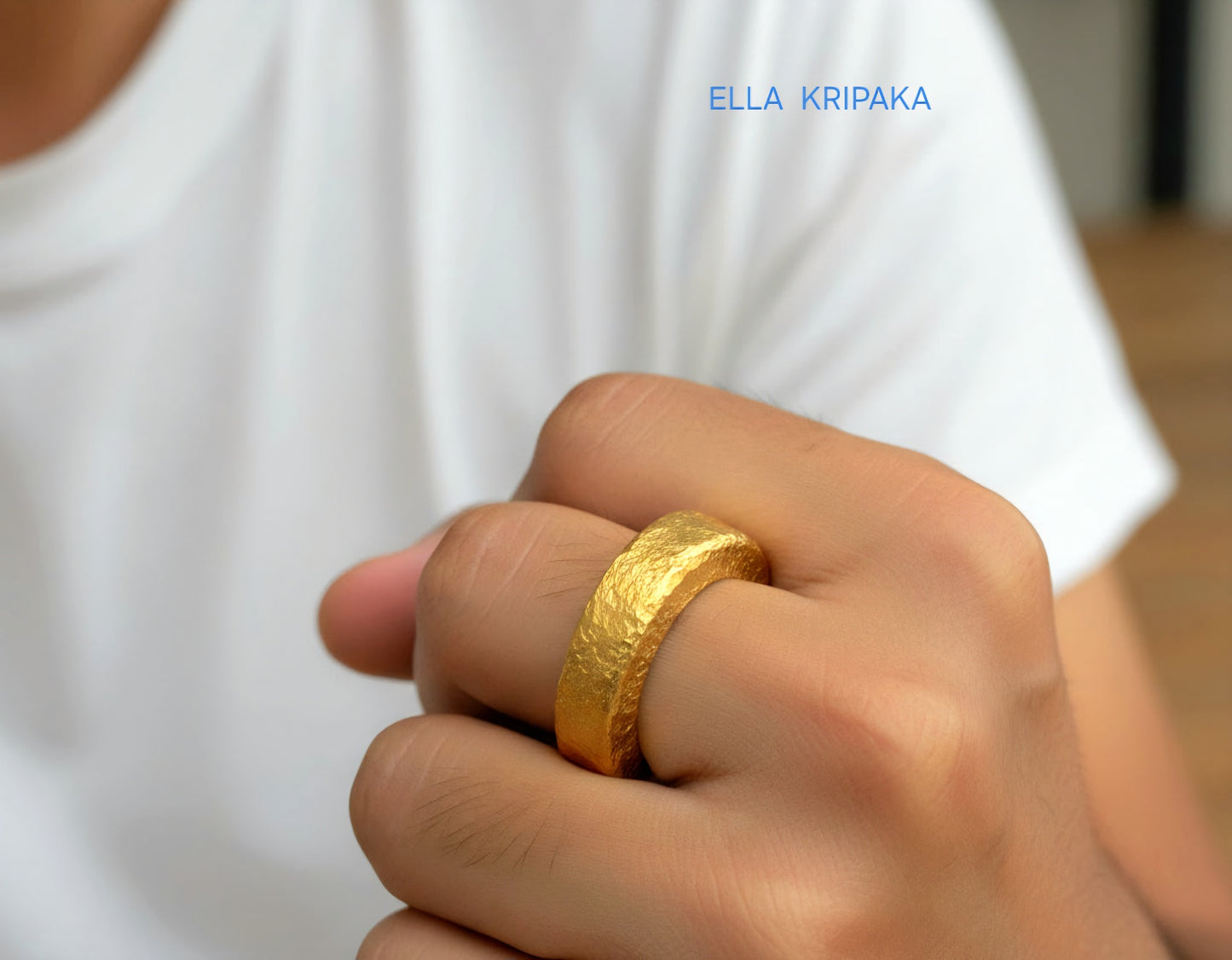 Hammered 24k 9999 Gold thick ring Ancient Rome style with a textured forged gold surface worn by a man on finger and on a white t-shirt background, branded 'Ella Kripaka'