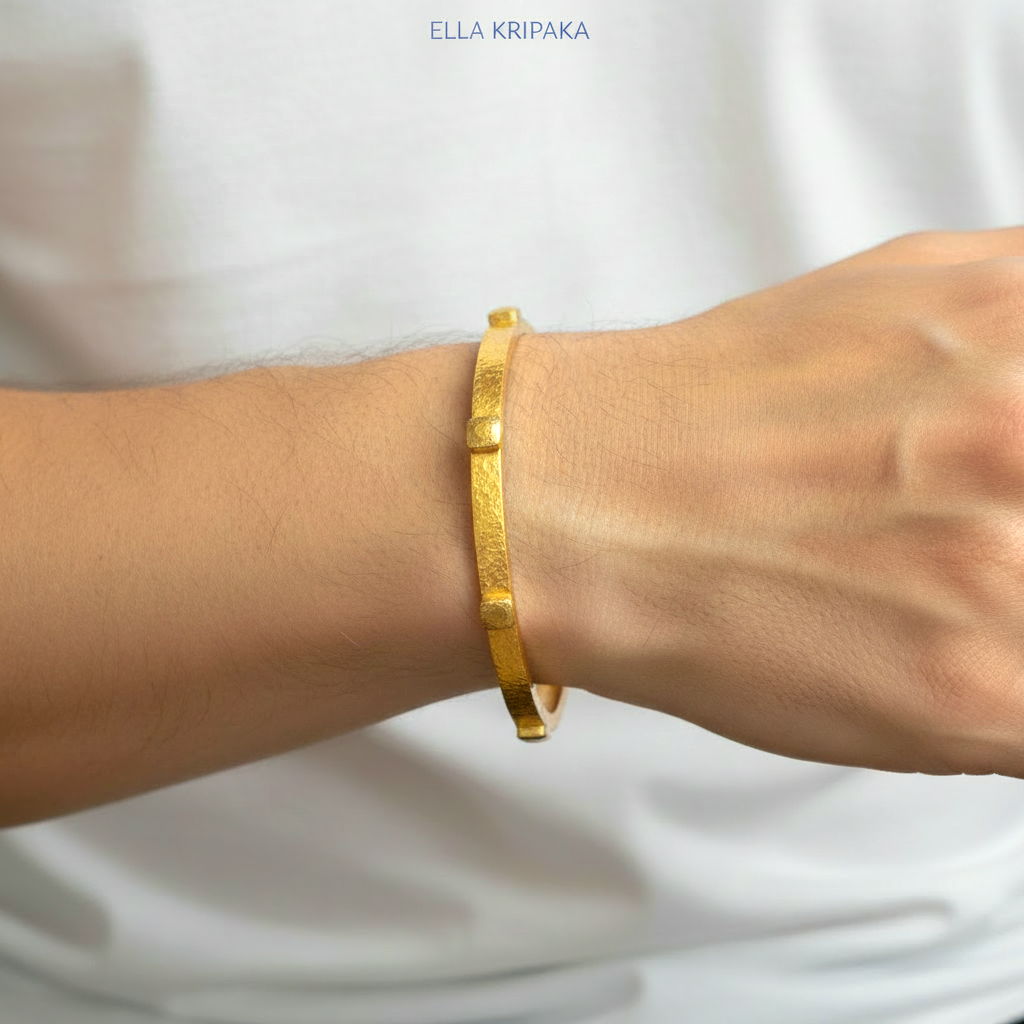 24k gold hammered bangle textured bracelet with thick squares is worn by a man on wrist and on white t-shirt background, artist 'Ella Kripaka' branding