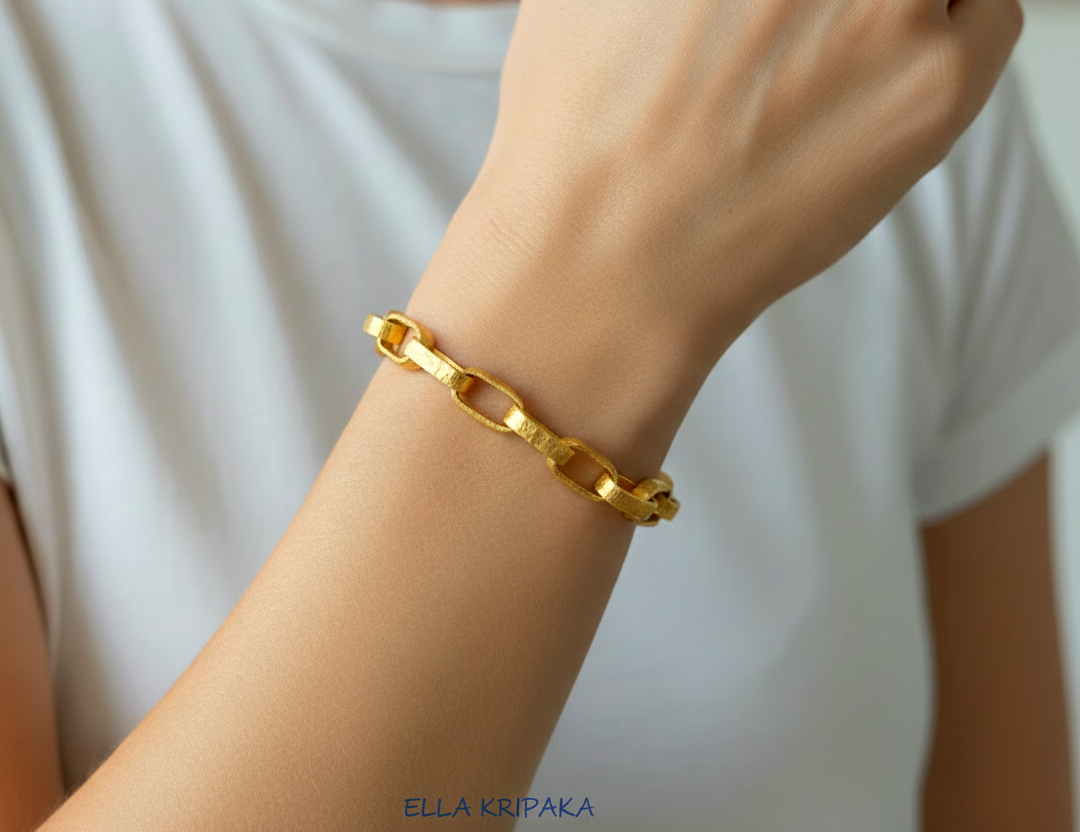 Hammered 24k 9999 gold chain thick bracelet Ancient Rome style worn on a woman's wrist and on white background, artist-jeweler name 'Ella Kripaka' branding