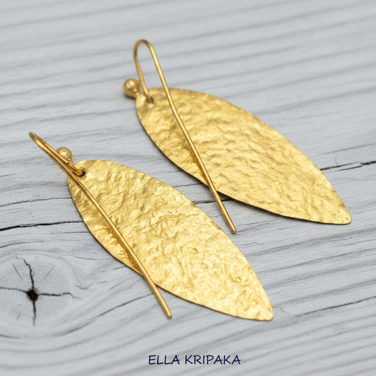 Hammered 24k Gold leaf textured earrings on a light grey wooden background with 'Ella Kripaka' branding
