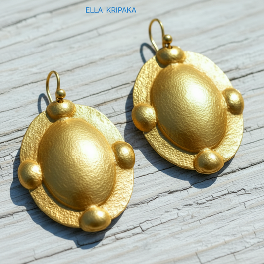 Hammered 24k gold five convex ovals earrings with shiny gold textures on light grey old wooden surface, artist 'Ella Kripaka' branding