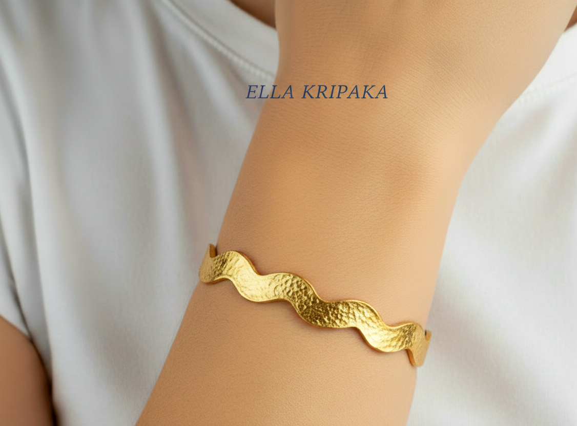 Hammered 24k 9999 Gold wavy bangle bracelet Ancient Egypt style worn on person's hand, artist's name 'Ella Kripaka' branding