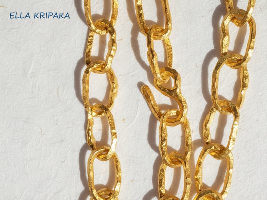 Organic 24k Gold hammered uneven textured chain 12mm of width and with thick hook clasp on a white craft paper surface, with artist 'Ella Kripaka' branding