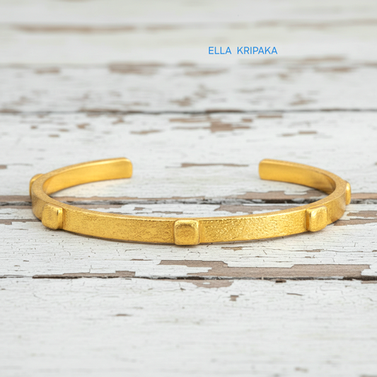 24k gold hammered cuff textured bracelet with thick squares on white rustic wooden surface, artist 'Ella Kripaka' branding
