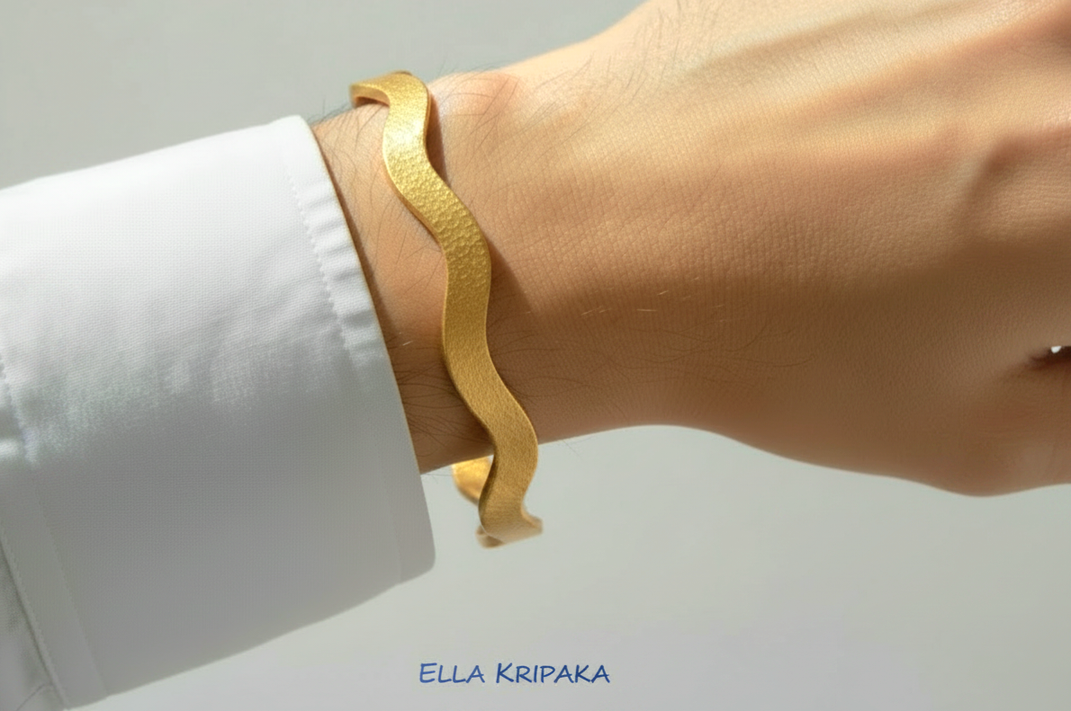 24k gold hammered bracelet textured bangle with wavy design is wearing on man's hand with white shirt and on neutral light background, branded 'Ella Kripaka'