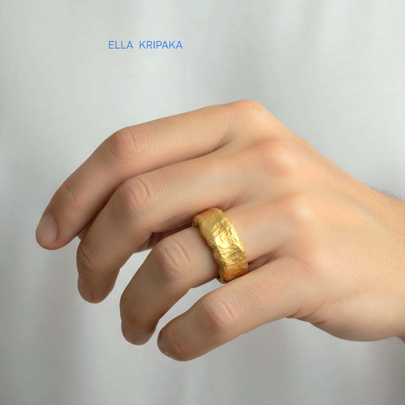 Hammered organic 24k Gold 9999 gold thick wavy ring band with textured gold worn on model's finger and on a white background, branded 'Ella Kripaka'