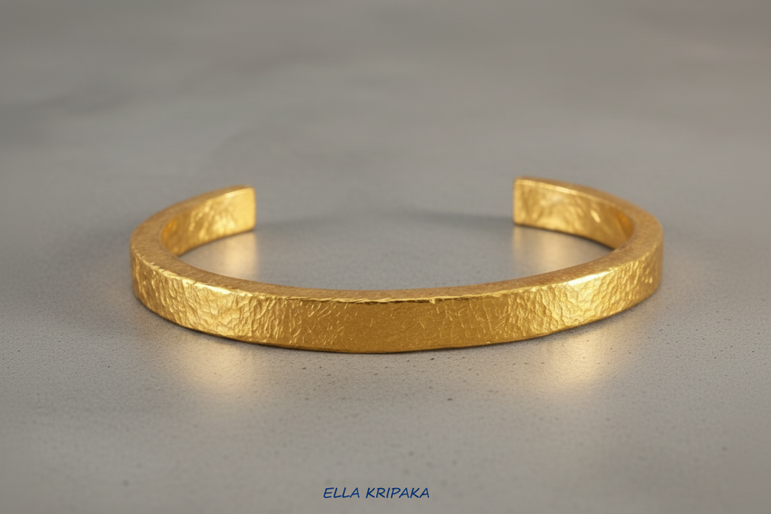 Hammered 24k Gold 9999 gold thick cuff bracelet Ancient Rome style with textured gold on grey background, branded 'Ella Kripaka'