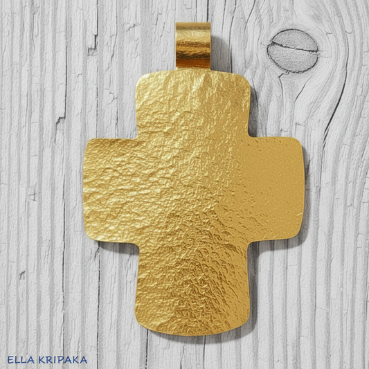 Hammered 24k gold textured cross pendant on a grey rustic wooden surface, artist-jeweler 'Ella Kripaka' branding