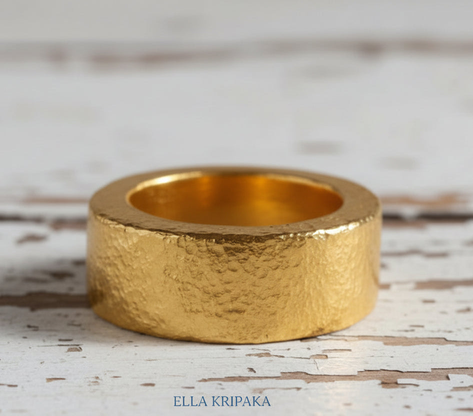 Hammered 24k Gold 9999 gold thick ring band Ancient Rome style with textured gold on old white wooden background, branded 'Ella Kripaka'