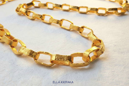 Hammered 24k chain necklace on a white paper background, branding artist-jeweler name 'Ella Kripaka'