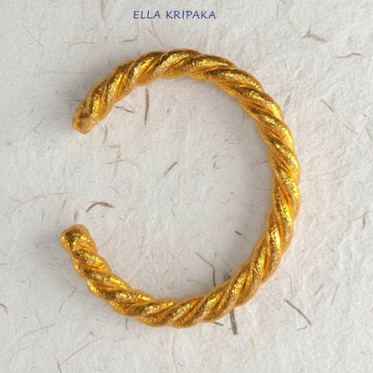 Twisted Viking Hammered 24k 9999 gold bracelet thick cuff on a white background, branding artist-jeweler name 'Ella Kripaka'