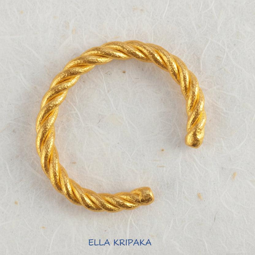 Twisted Viking Hammered 24k 9999 gold bracelet thick cuff on a white background, branding artist-jeweler name 'Ella Kripaka'