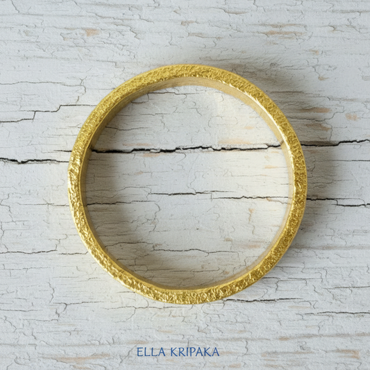 Hammered 24k 9999 Gold thick bangle bracelet Ancient Rome style on old wooden surface, artist's name 'Ella Kripaka' branding