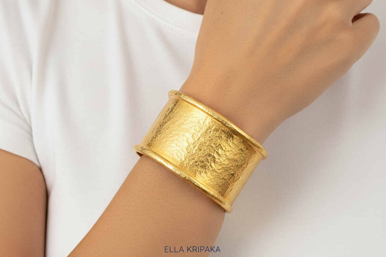 Hammered 24k 9999 gold bracelet large cuff Ancient Rome style with thick borders on a wiman's wrist, branding artist-jeweler name 'Ella Kripaka'
