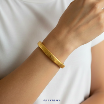 Hammered 24k 9999 gold bracelet cuff Ancient Rome style is worn by a woman and with a white t-shirt background, branding artist-jeweler name 'Ella Kripaka'