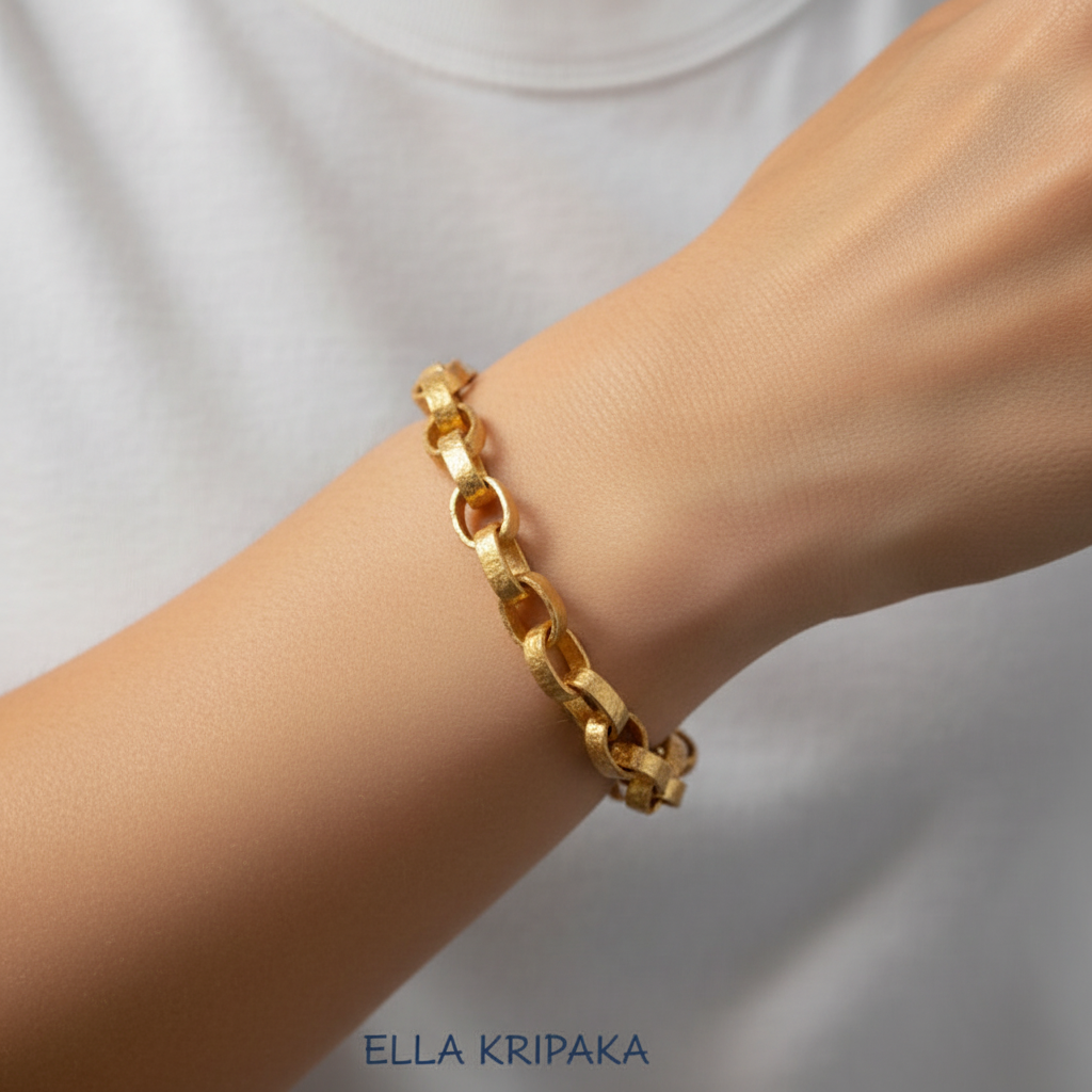 Hammered 24k 9999 gold chain thick bracelet Ancient Rome style worn by a model on hand and on a grey background, artist-jeweler name 'Ella Kripaka' branding