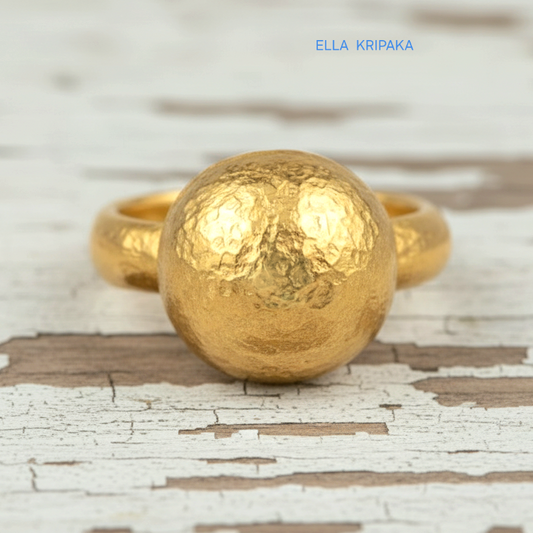 Hammered 24k 9999 Gold ring with convex disk signet Ancient Rome style and with forged textured gold on a white old wooden surface, artist-jeweler's name 'Ella Kripaka' branding
