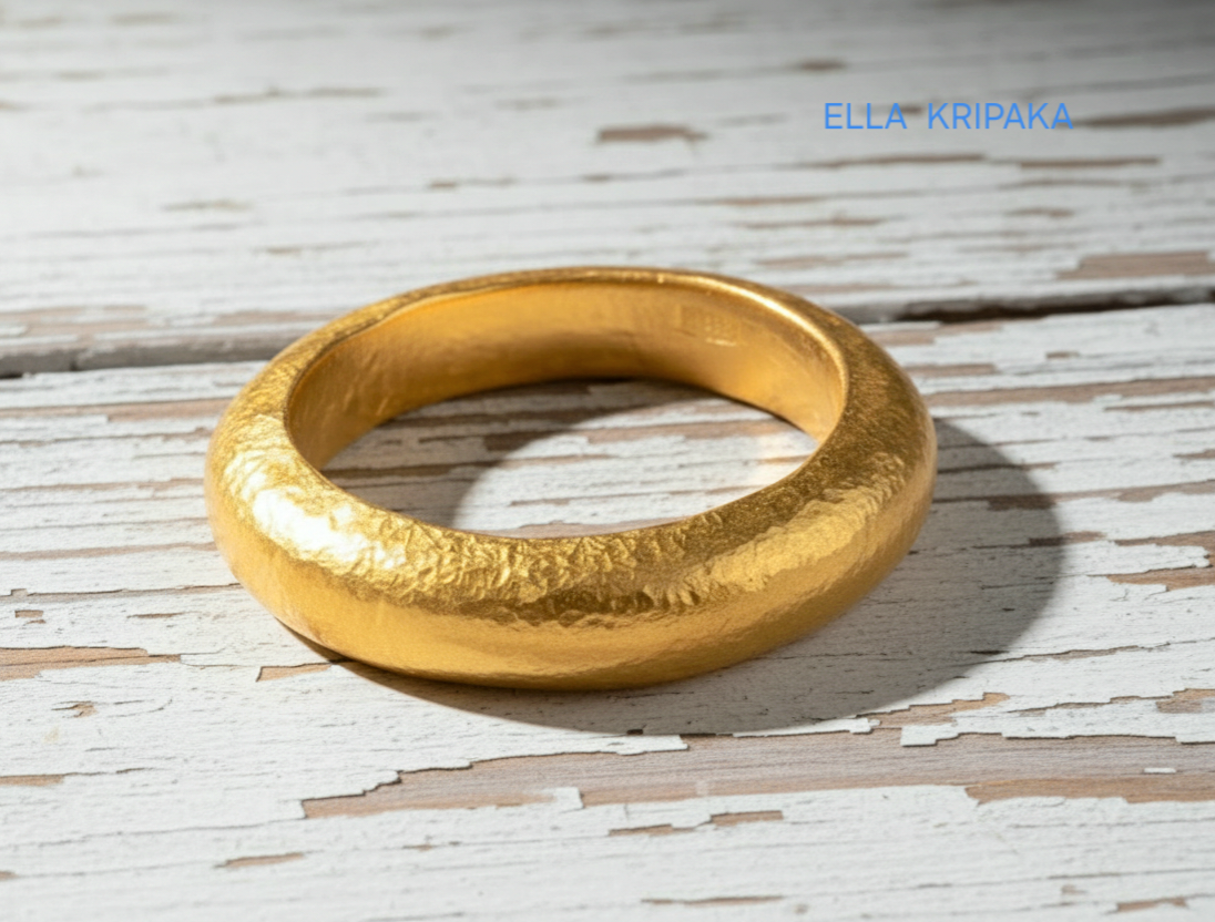 Hammered 24k 9999 Gold thick ring Ancient Rome style and with forged textured gold on a white old wooden surface, artist-jeweler's name 'Ella Kripaka' branding