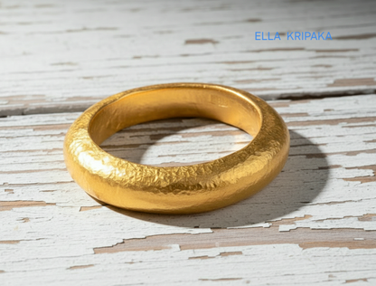 Hammered 24k 9999 Gold thick ring Ancient Rome style and with forged textured gold on a white old wooden surface, artist-jeweler's name 'Ella Kripaka' branding
