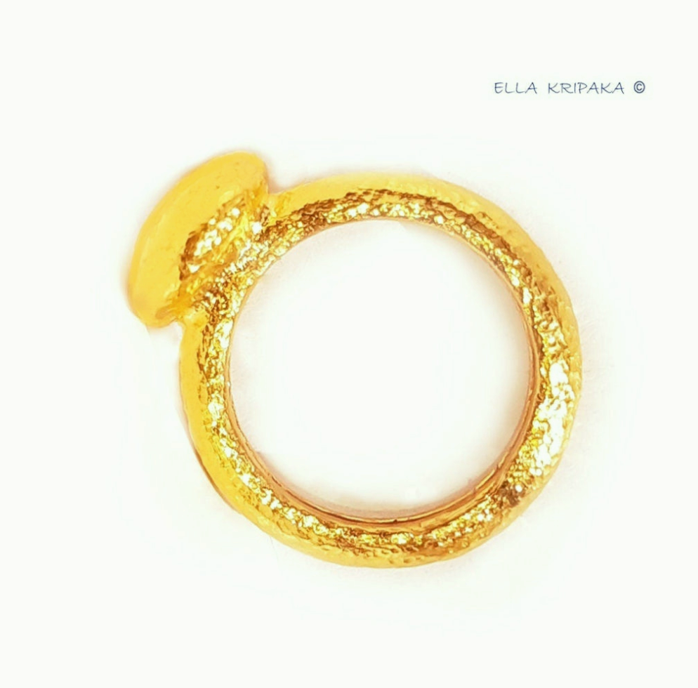 Hammered 24k 9999 Gold ring with convex disk signet Ancient Rome style and with forged textured gold on a white  surface, artist-jeweler's name 'Ella Kripaka' branding