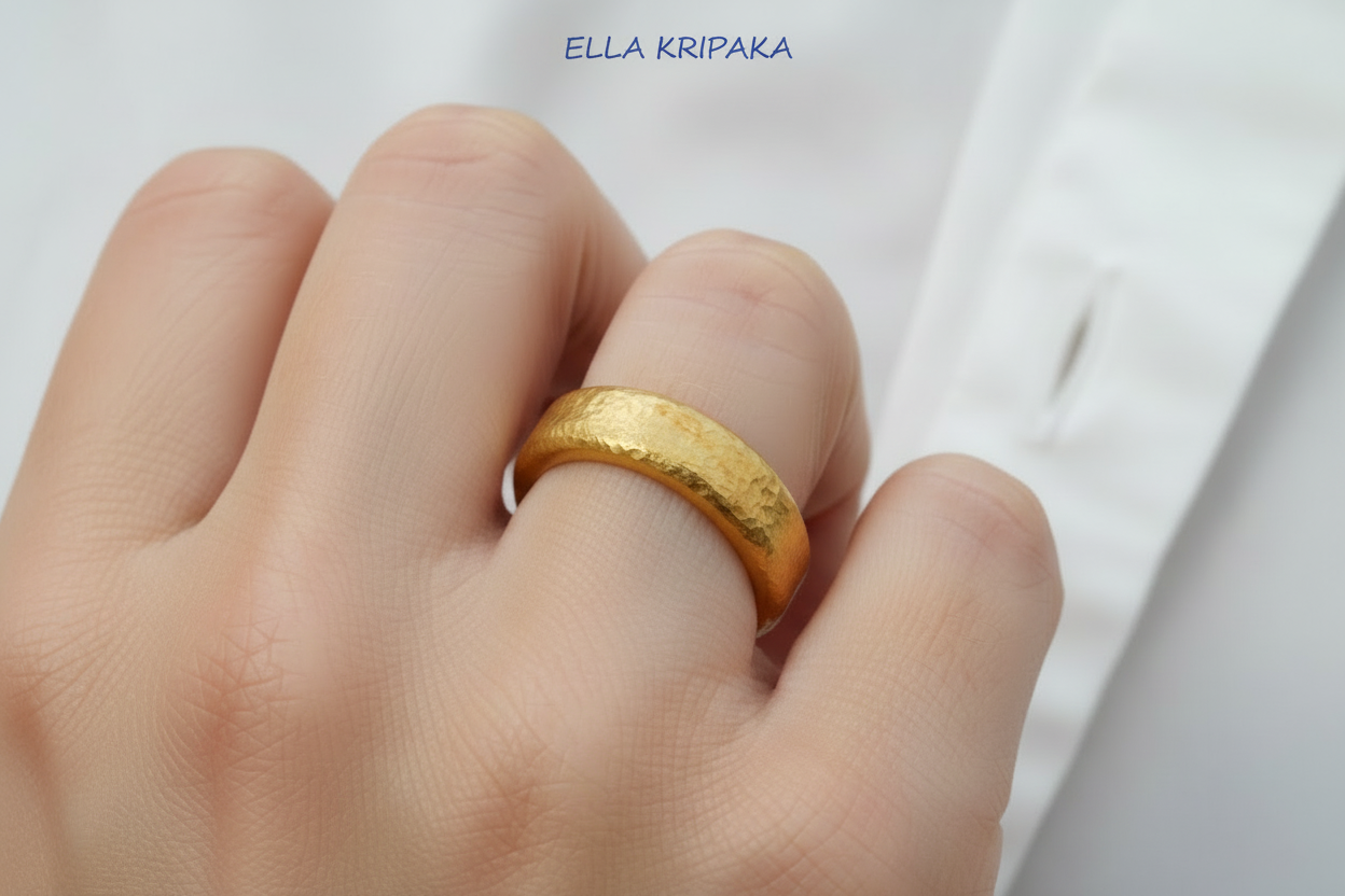 24k gold hammered Gold ring on a finger with a plain background