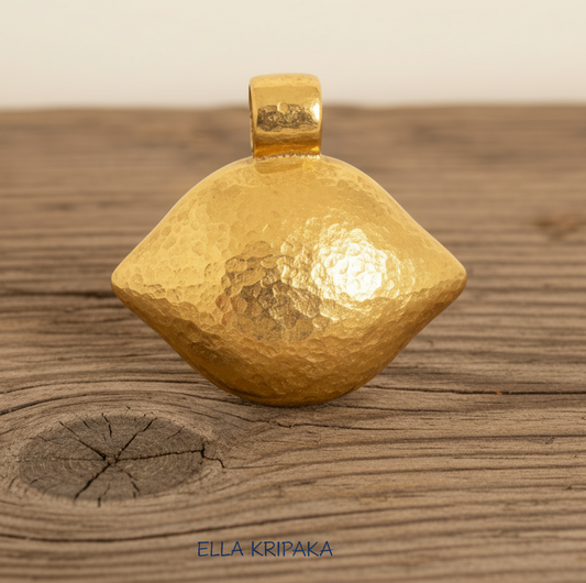 24k 9999 gold hammered Byzantine dine pendant with shiny forged gold textures is on a old wooden surface, artist's name 'Ella Kripaka'