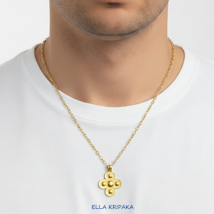24k 9999 gold hammered Byzantine cross pendant on chai is worn by person in a white t-shirt, artist's name 'Ella Kripaka'