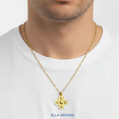 24k 9999 gold hammered Byzantine cross pendant on chai is worn by person in a white t-shirt, artist's name 'Ella Kripaka'