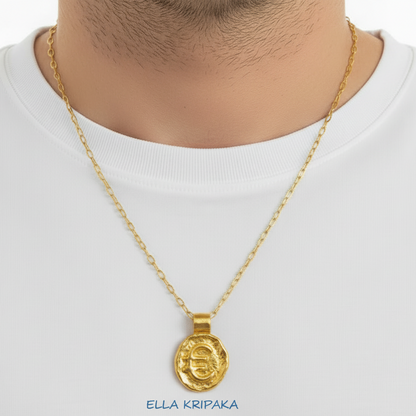 Hammered 24k 9999 Gold organic uneven pendant with convex 'Euro Sign' is with chain wearing on  man in white t-shirt, artist's name 'Ella Kripaka' 
