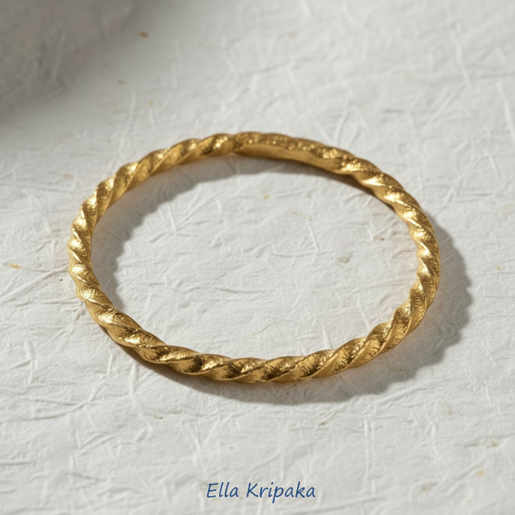 Twisted Viking Hammered 24k 9999 Gold bangle bracelet on white paper surface, artist's name 'Ella Kripaka' branding