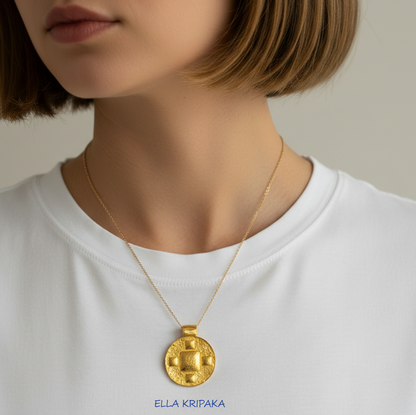 24k gold disk pendant textured hammered with convex pattern and with thin chain is worn by a woman and on light grey background, with 'Ella Kripaka' branding