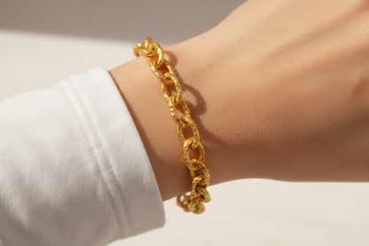 Hammered 24k 9999 gold organic bracelet chain with hammered uneven textures worn by a woman on wrist and on a white surface, artist name 'Ella Kripaka'
