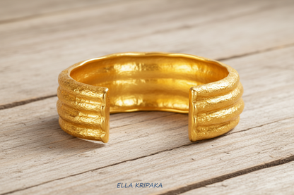 Organic 24k 9999 gold uneven cuff with textured design on a white background, branded 'Ella Kripaka'