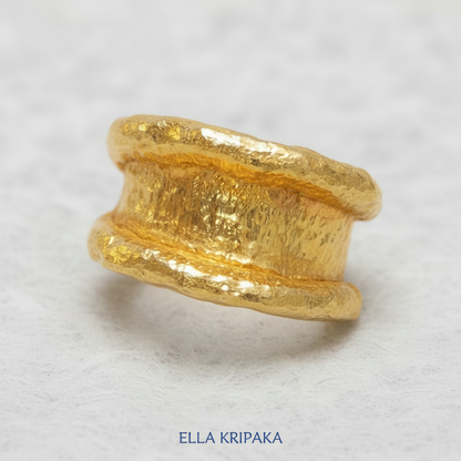 Organic hammered 24k 9999 Gold ring with thick uneven edges on white paper surface, artist-jeweler's name 'Ella Kripaka' is written in picture