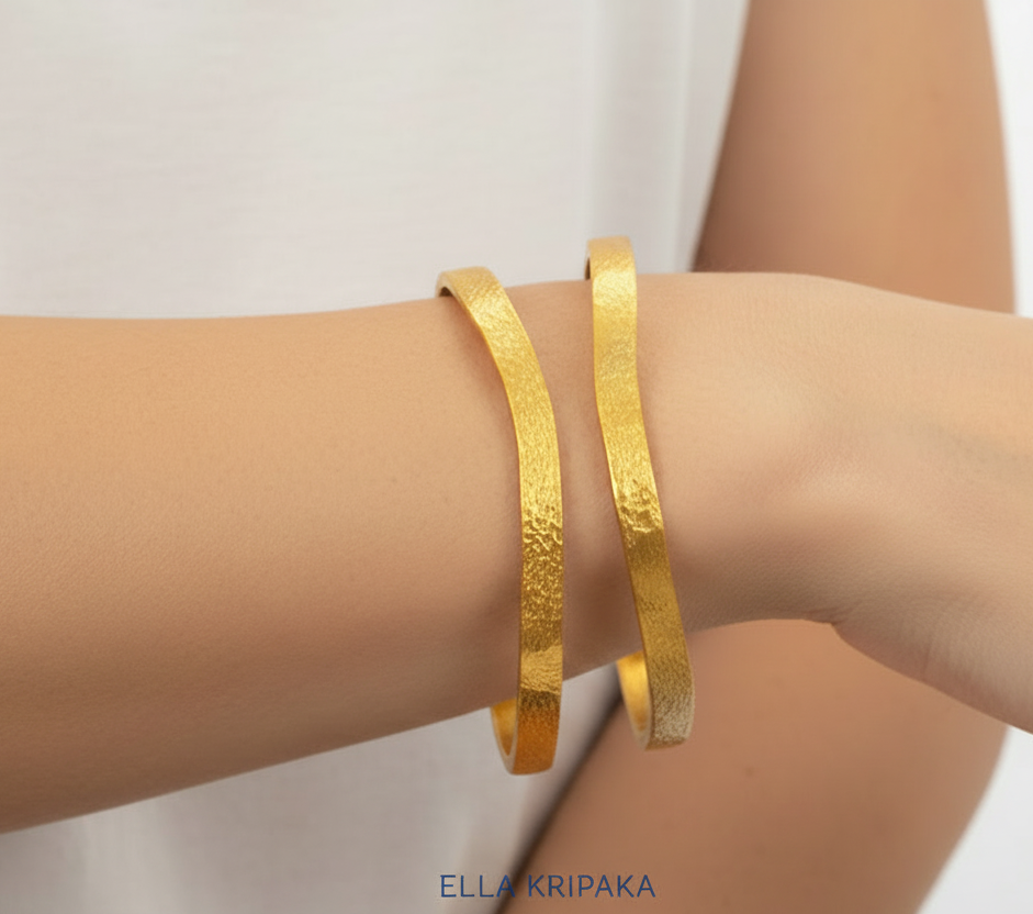 Organic 24k gold 9999 gold hammered two uneven bangles thick bracelets with uneven forms on woman' s wrist, forged 24k gold jewelry, artist-jeweler 'Ella Kripaka'