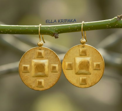 Hammered 24k 9999 Gold Byzantine earrings hanging on a branch with 'Ella Kripaka' branding