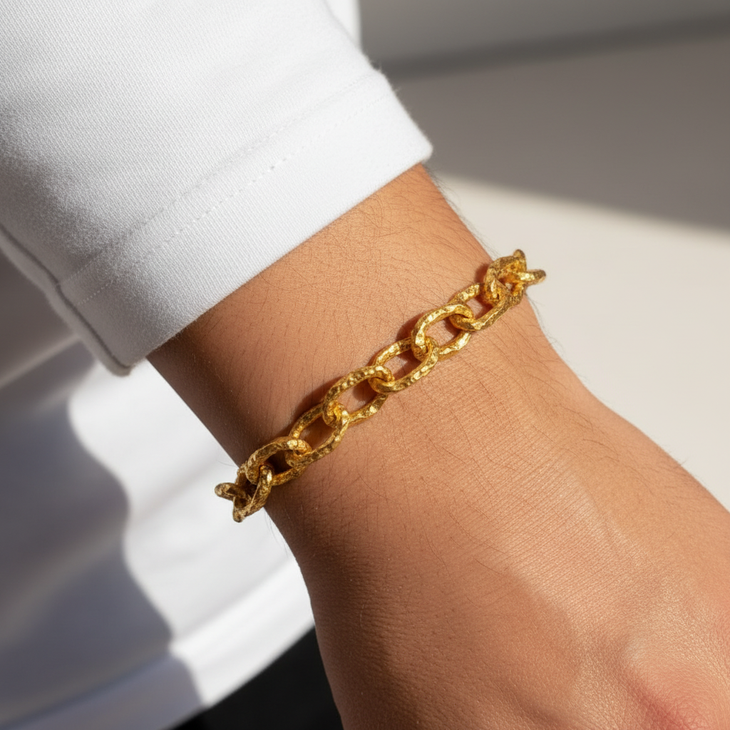 Hammered 24k 9999 gold organic bracelet chain with hammered uneven textures worn by a man on wrist and on a white surface, artist name 'Ella Kripaka'